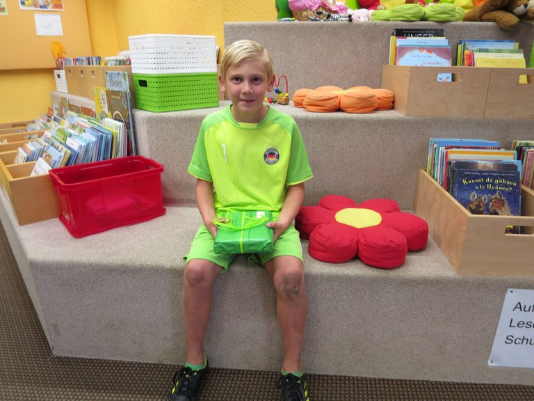 Der achtjährige Eldin Dindic mit seinem Sommerlesen-Gewinn in der Bibliothek Rankweil © Bibliothek Rankweil
